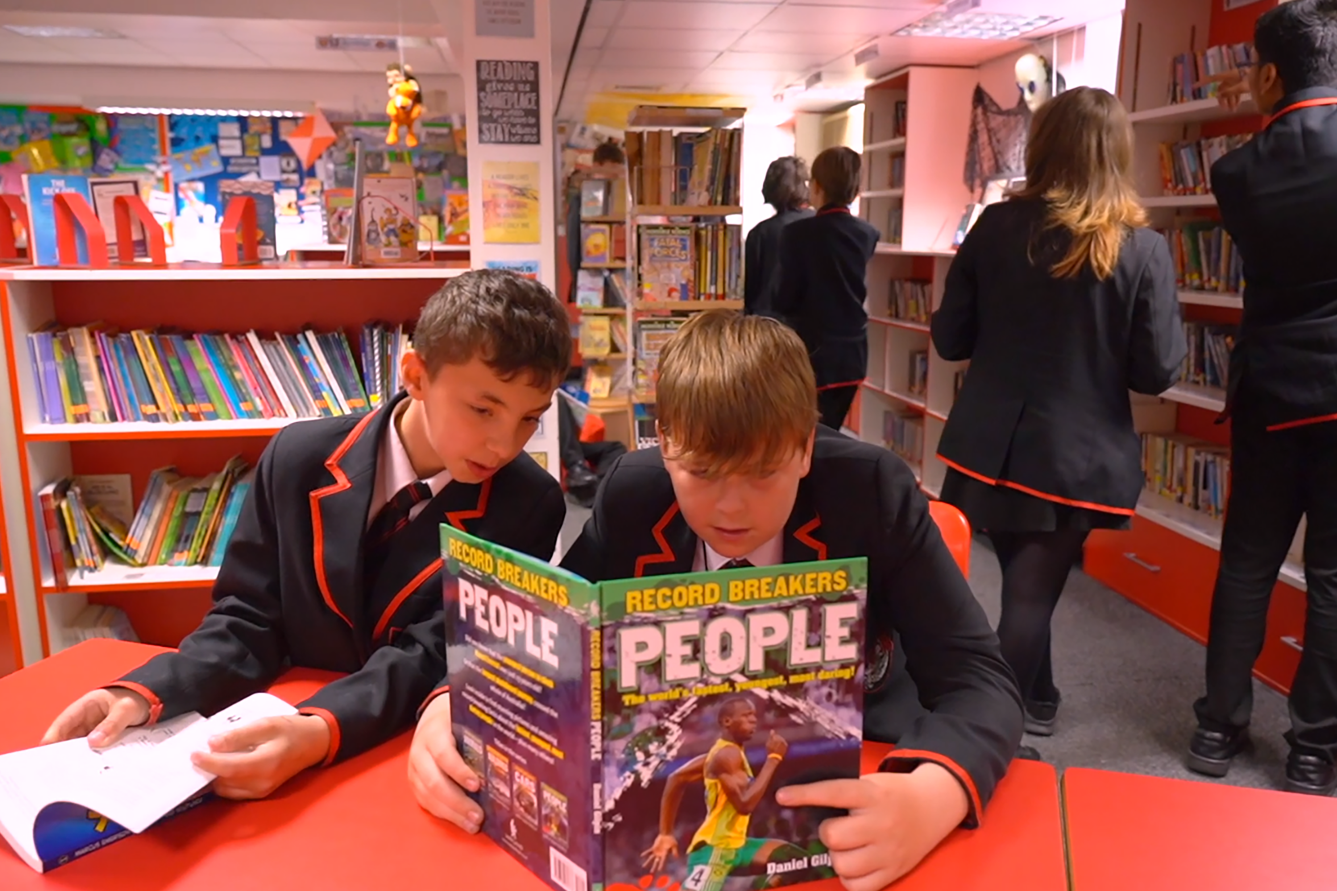 Pic of two school boys reading in a library to highlight the Cradle to Career programme