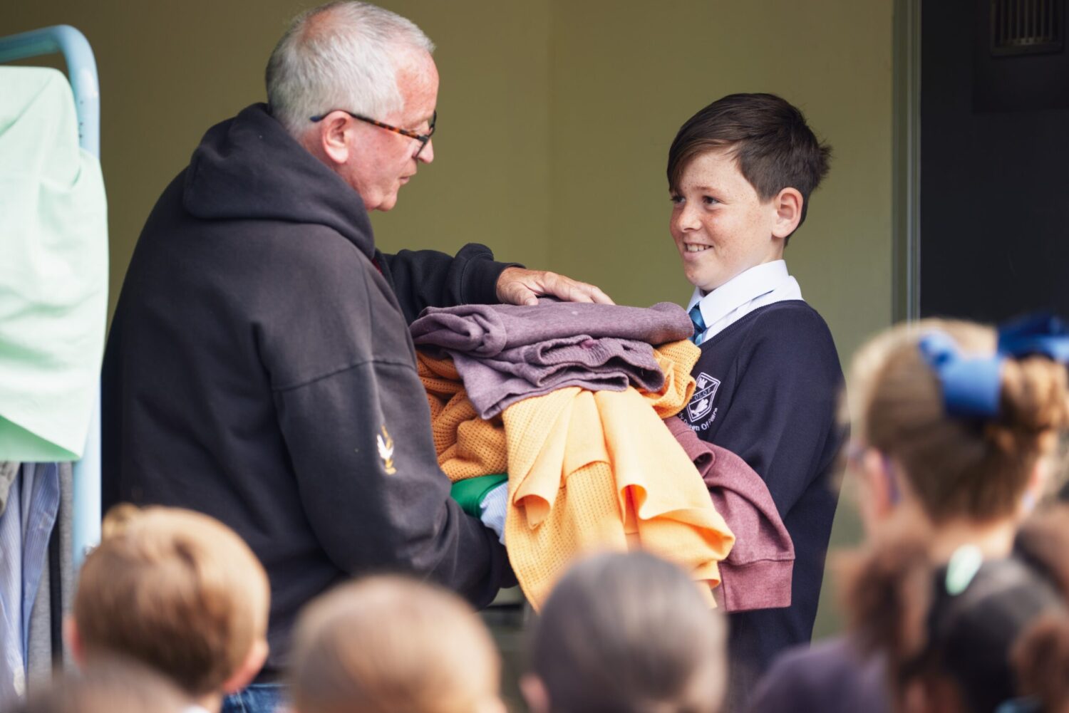 CELLS staff member handing sample prison uniform to school child as part of education demonstration on making the right choices