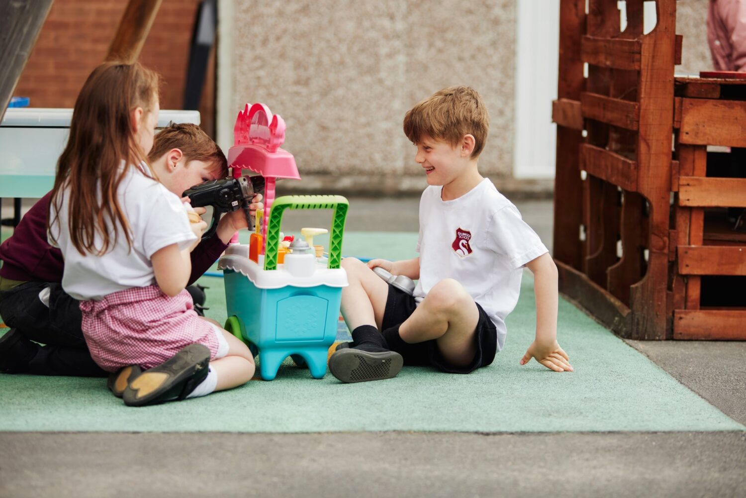 Three children playing make believe in school playground