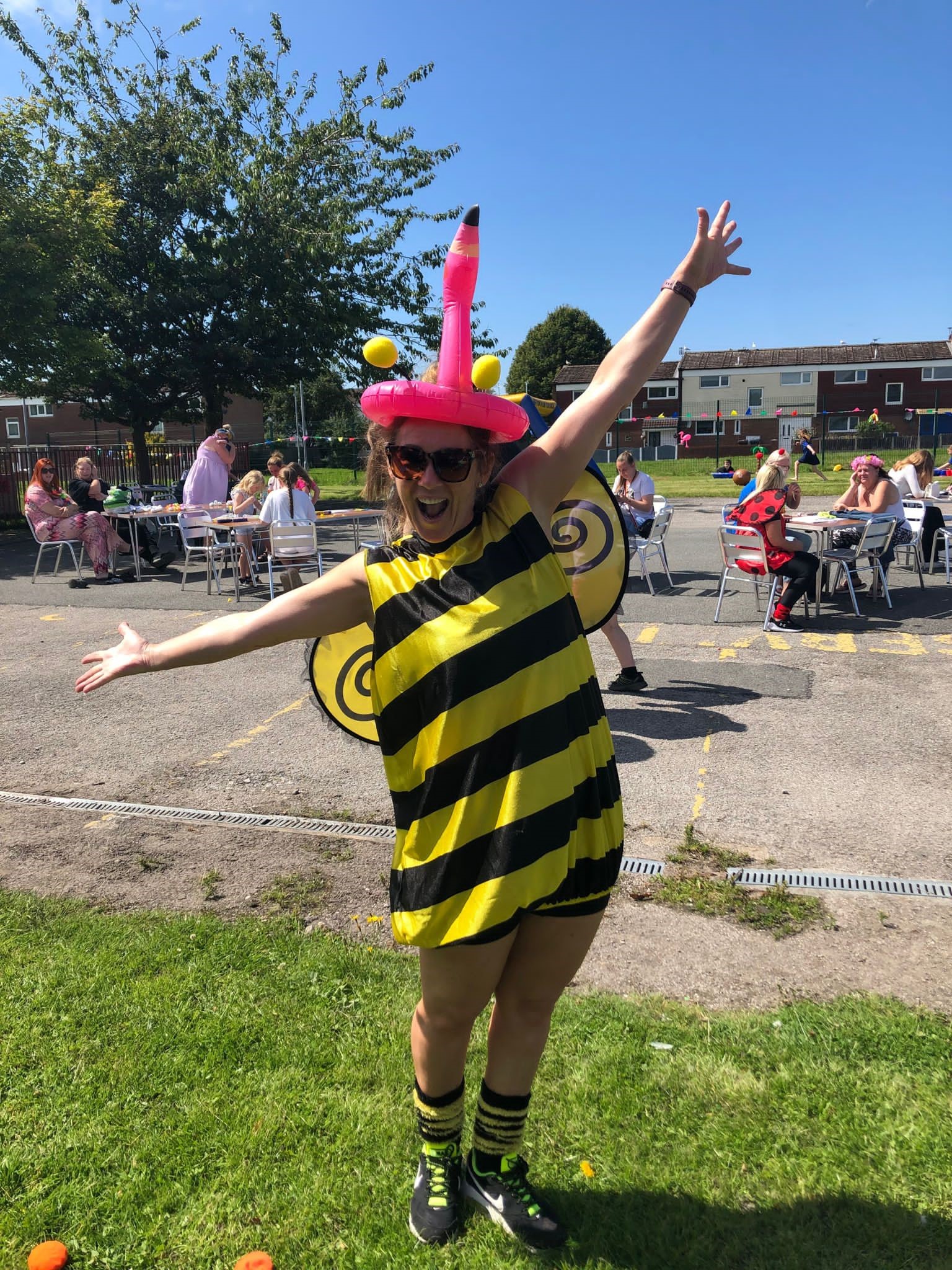 A smiley woman poses in a bumblebee costume as part of a Fun 4 Kidz initiative.