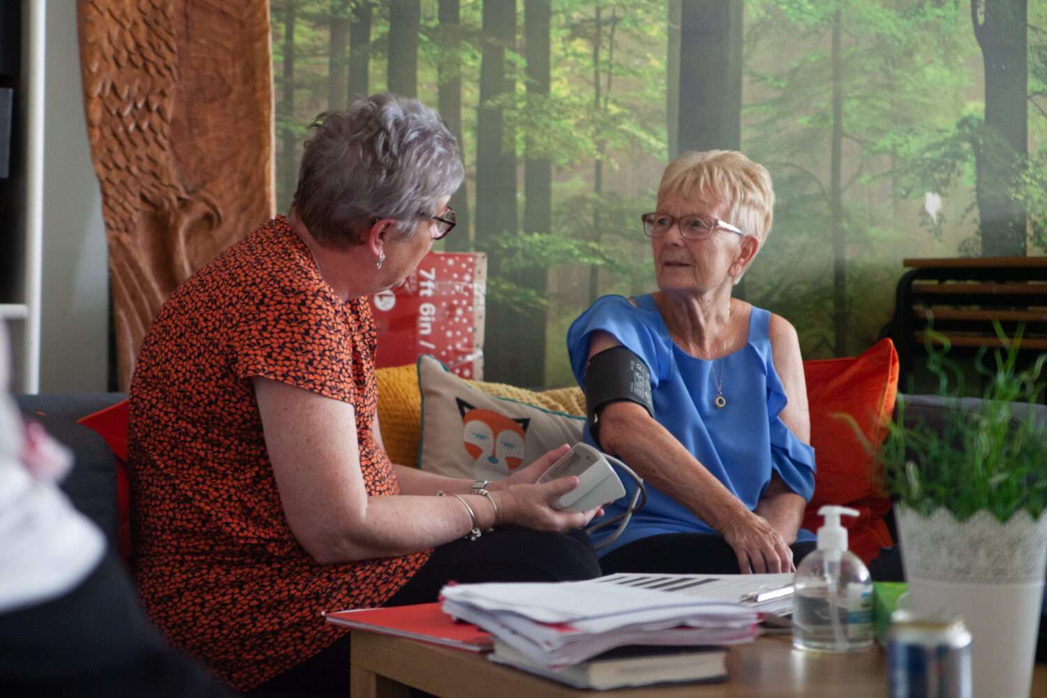 A woman taking the blood pressure of another woman as part of a Venus Charity initiative