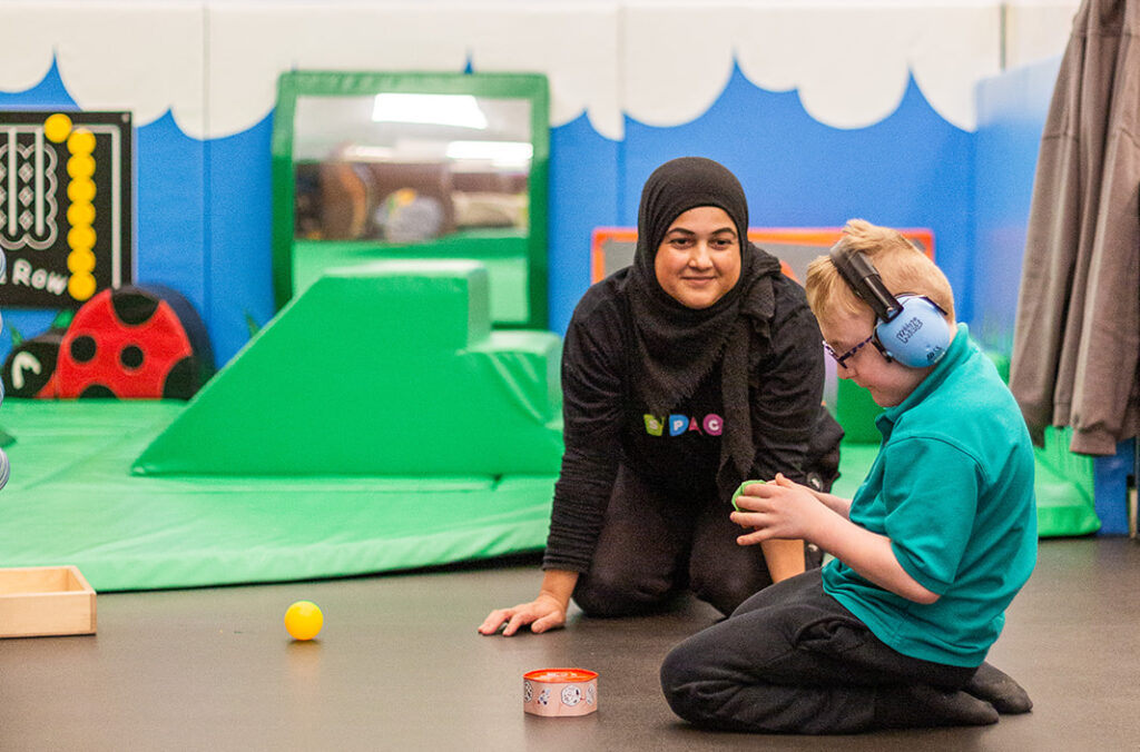 Staff member at SPACE charity playing with a child with additional needs at after school club